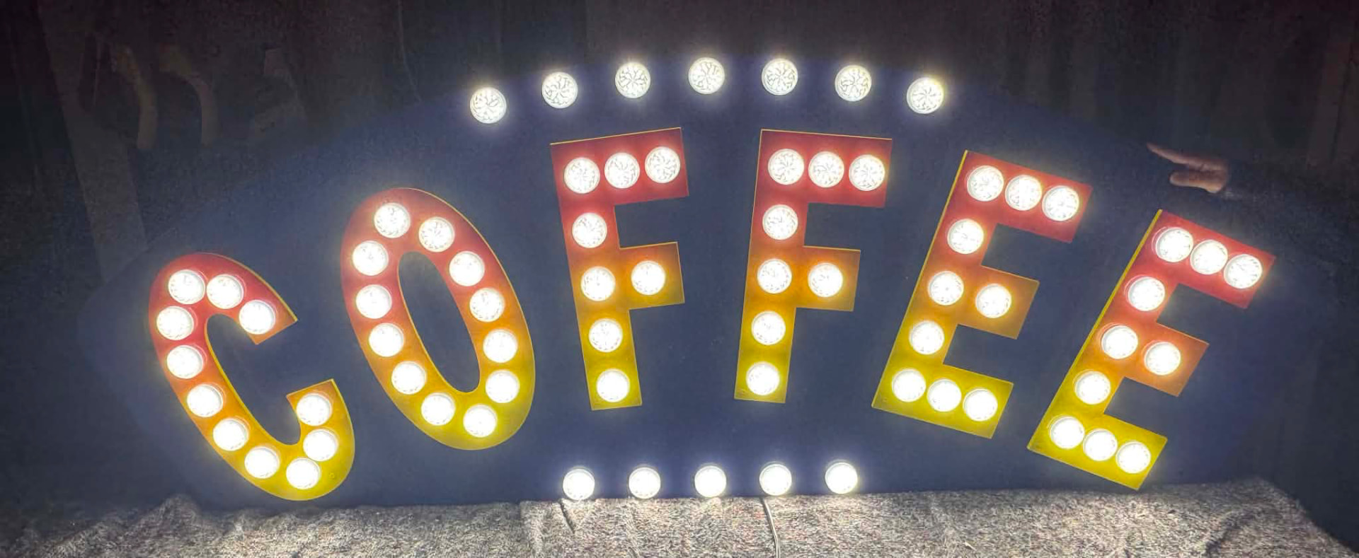 Large illuminated marquee-style COFFEE sign with lit bulbs and halo border