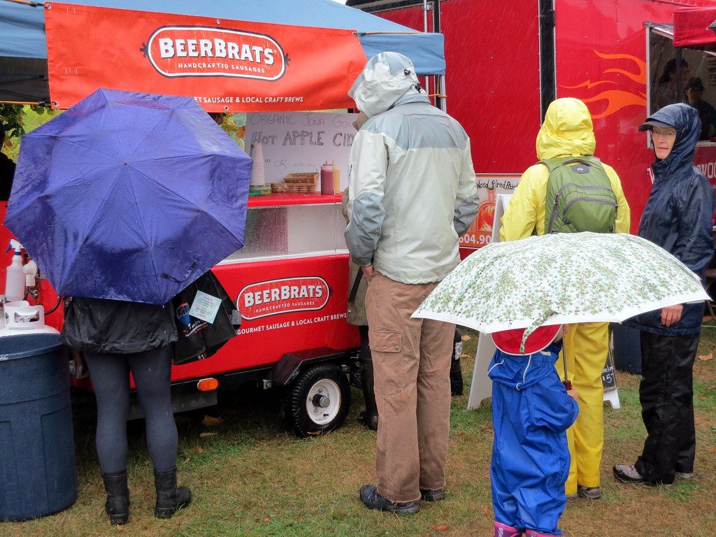 Branded gazebo market stall serving customers at an outdoor event