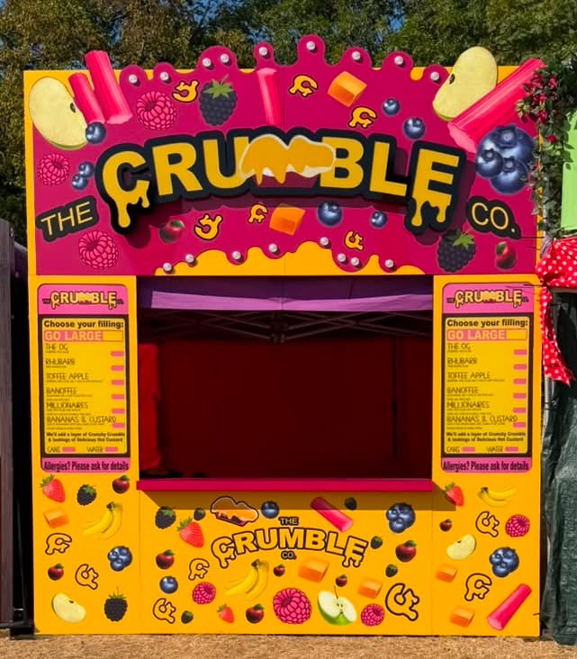 The Crumble Co. colourful festival stand with bright pink and yellow branded frontage