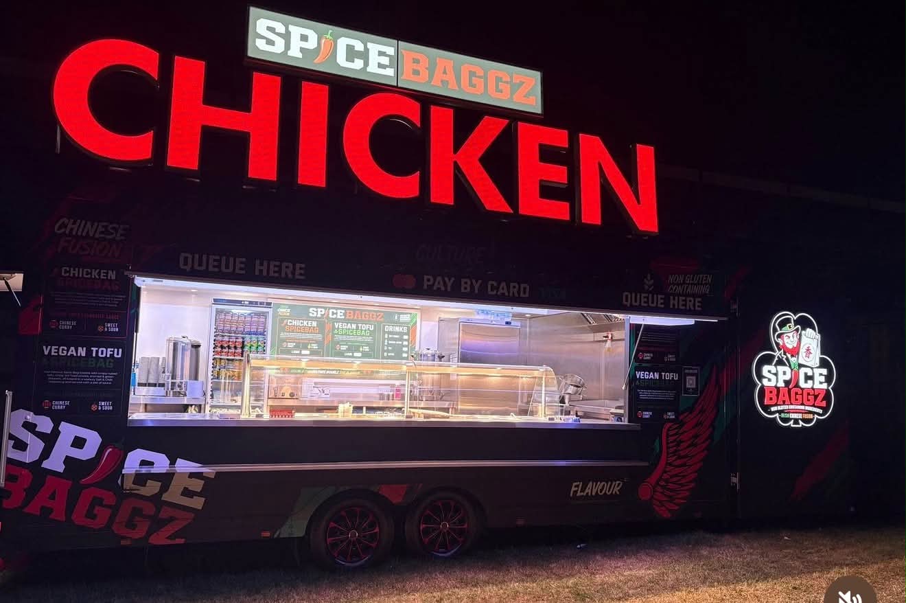 Spice Baggz Chicken food trailer with large red illuminated top signs and branded serving side
