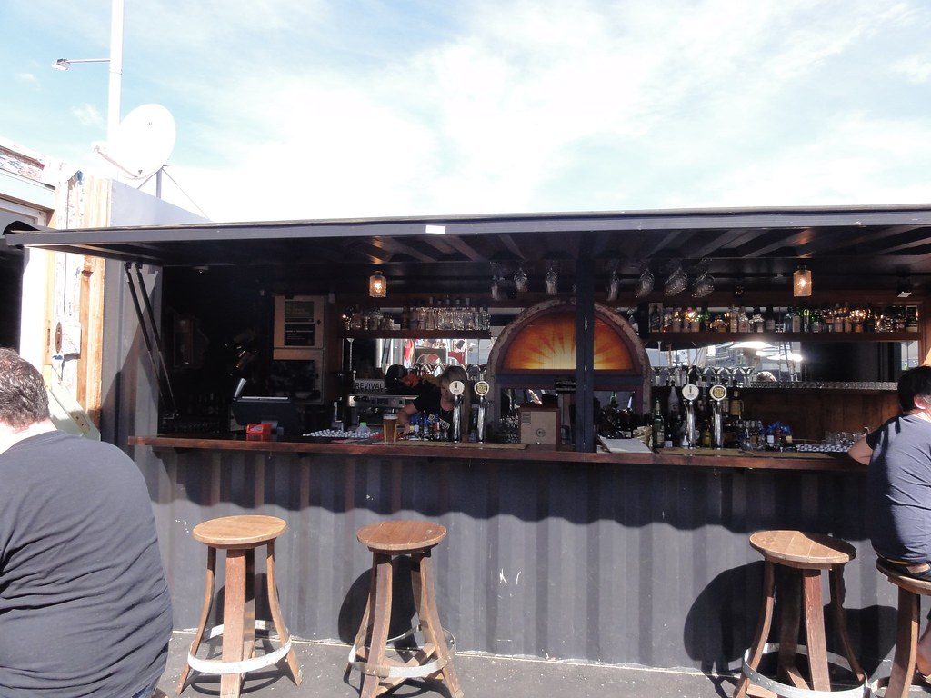 Shipping container converted into an open-fronted bar with a timber counter