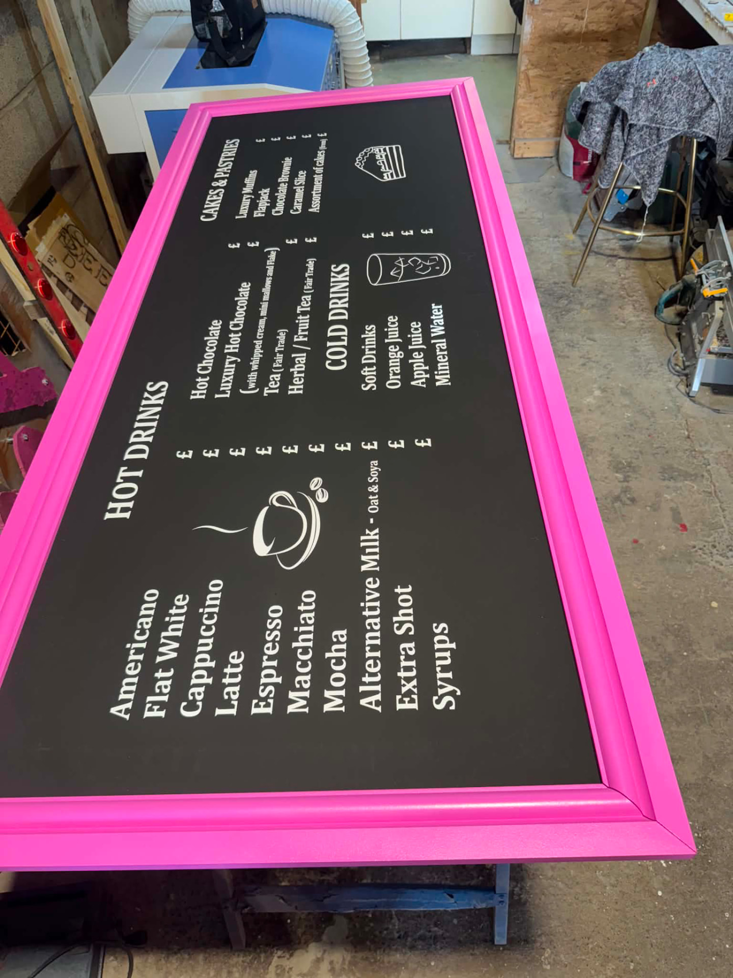 Pink-framed bespoke menu board with hot drinks, cold drinks and cakes sections
