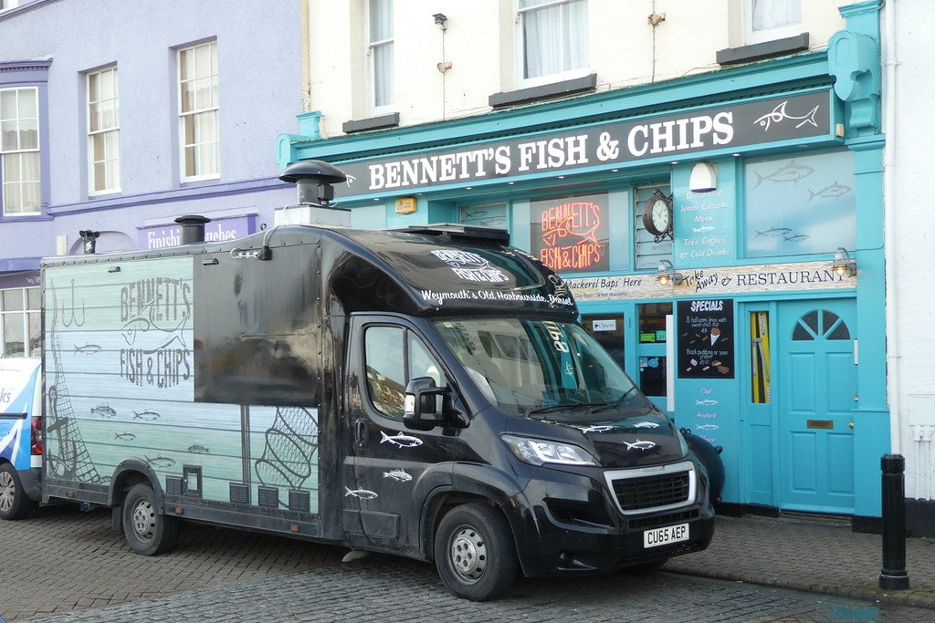 Fish and chips van with large branded signage along the serving side