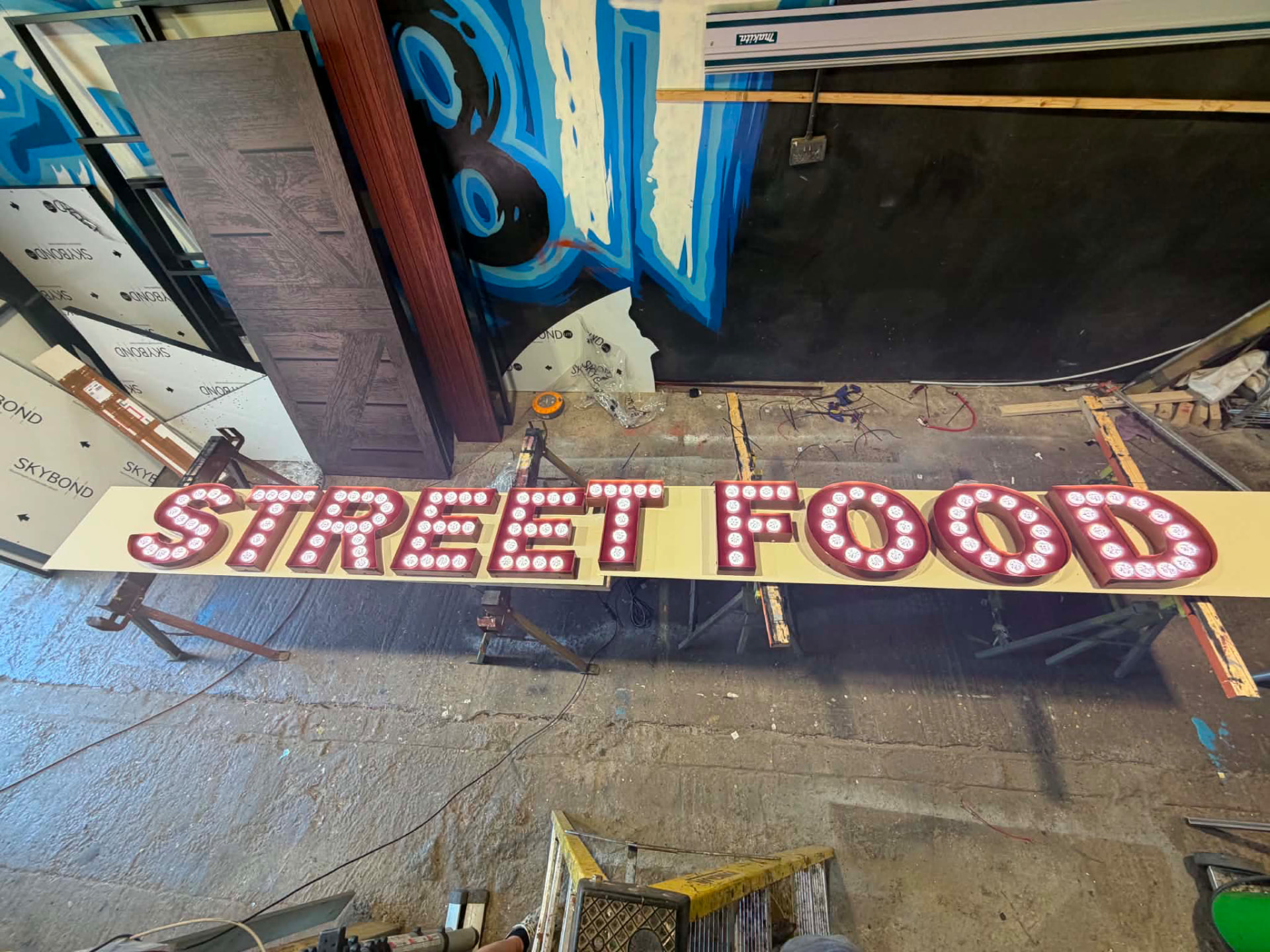 Large illuminated STREET FOOD 3D letters built up with LED bulbs in the workshop
