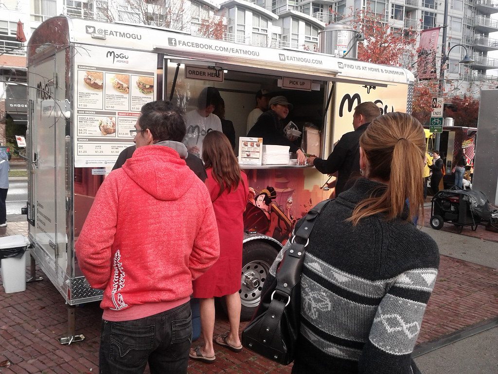 Food trailer serving a queue of customers through twin hatches