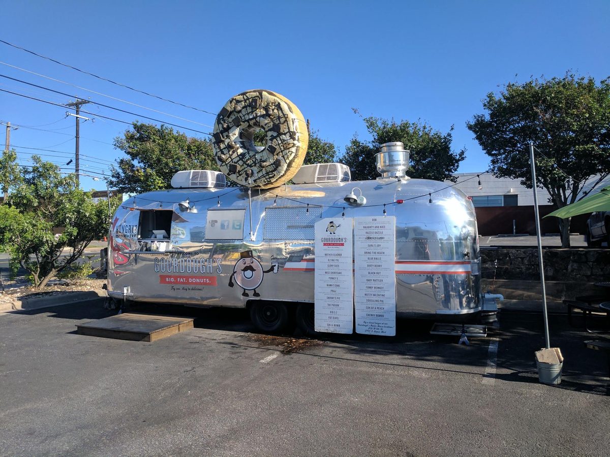 Food trailer with a large sculpted top sign mounted above the serving hatch